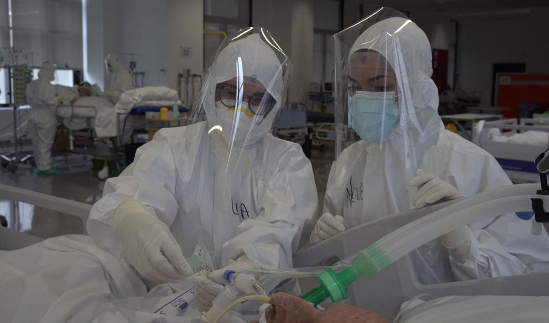 Personal sanitario atendiendo a un paciente de COVID-19 en la UCI.