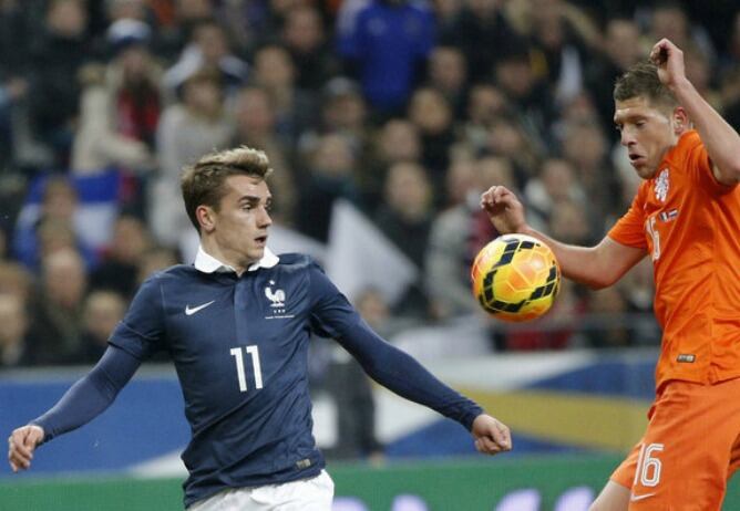 Griezmann disputa un balón con un jugador holandés en su debut con Francia en París.