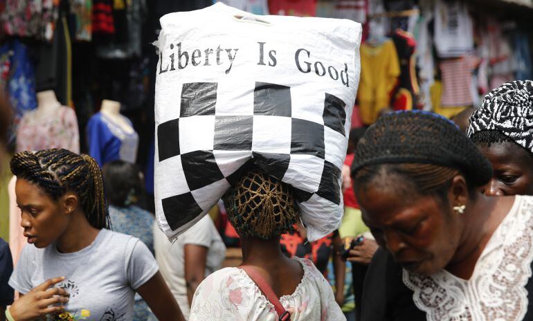 Una joven nigeriana acarrea un saco donde puede leerse: &quot;La libertad es buena&quot;