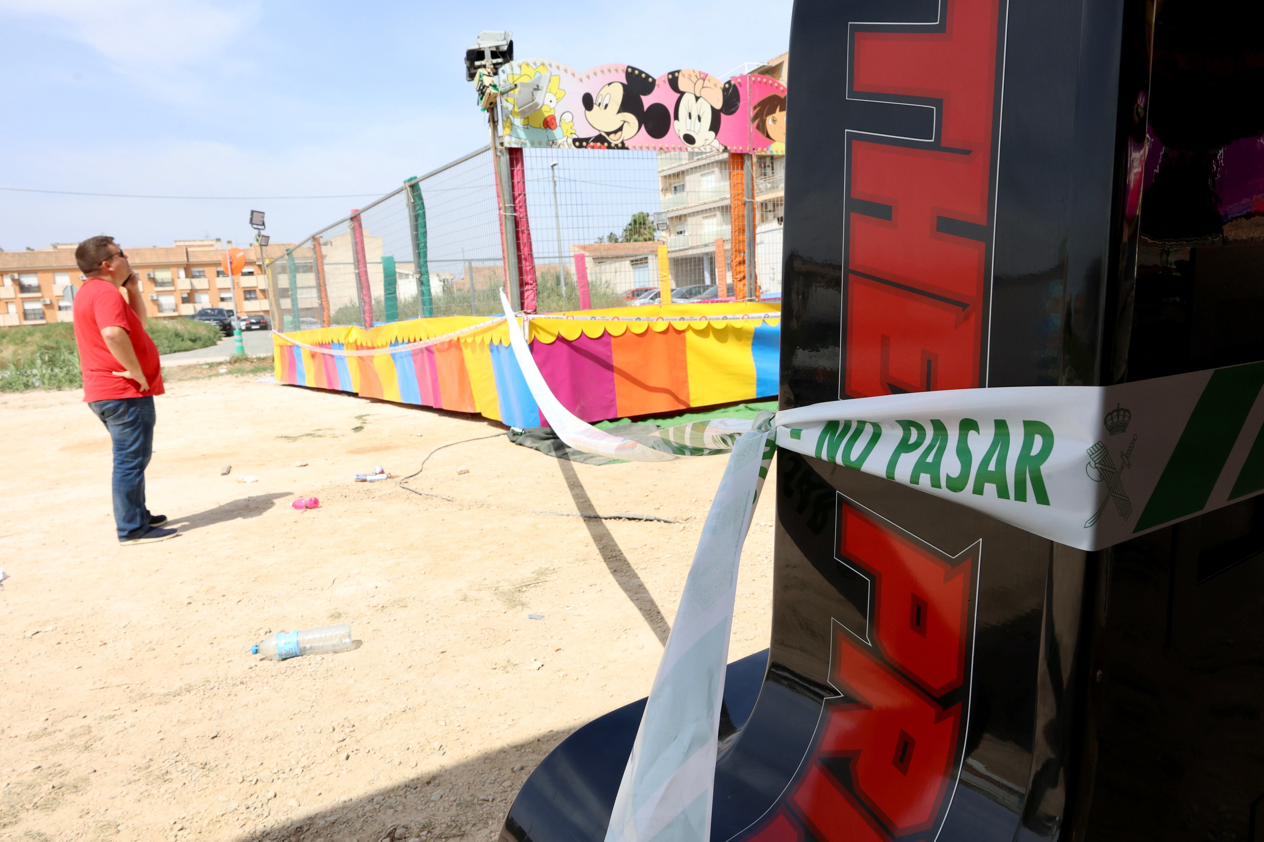 ALQUERÍAS (MURCIA), 15/06/2025.- Un hombre observa las camas elásticas del recinto ferial de la pedanía murciana de Alquerías después de que una niña de dos años falleciera esta madrugada al recibir una descarga eléctrica. EFE/ Juan Carlos Caval