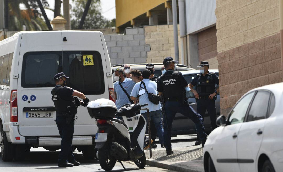 Varios agentes y vehículos de la Policía Local de Ceuta acompañan a menores no acompañados hacia una furgoneta, en las inmediaciones del Polideportivo Santa Amelia, donde fueron acogidos 250 de los 800 menores que llegaron a Ceuta el pasado mes de mayo.