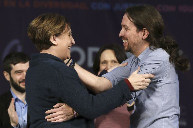 El líder de Podemos y candidato a la Presidencia del Gobierno, Pablo Iglesias, saluda a la alcaldesa de Barcelona, Ada Colau, durante el acto político que ha protagonizado en la Caja Mágica de Madrid.