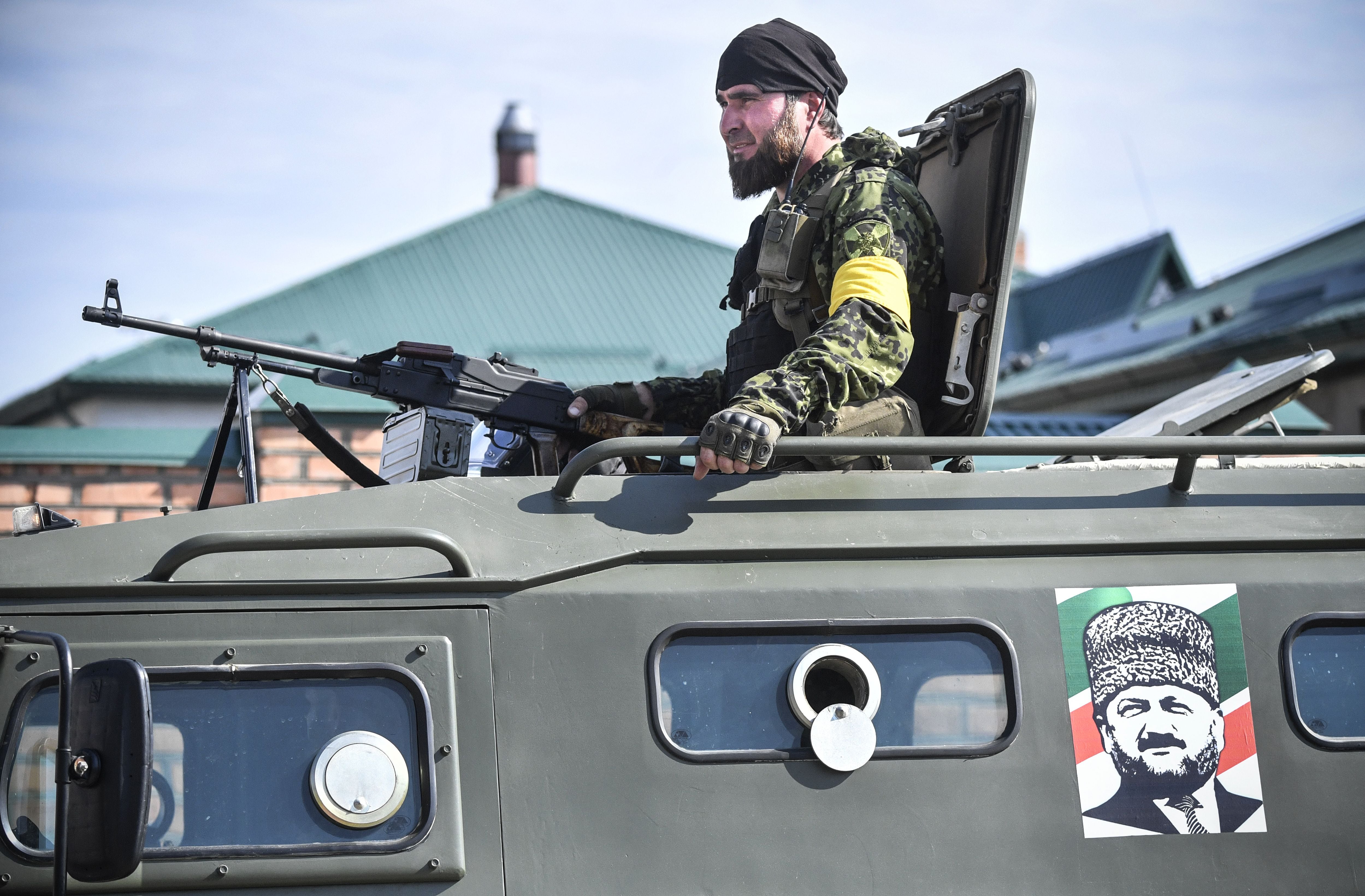 Un soldado de las fuerzas especiales chechenas se sienta encima de un APC decorado con un retrato del ex presidente checheno Akhmad Kadyrov, el padre del actual líder checheno Ramzan Kadyrov, durante una sesión de entrenamiento en un centro de entrenamiento de fuerzas especiales de la &#039;Universidad Spetsnaz rusa&#039; en la ciudad de Gudermes en Chechenia el 25 de julio de 2019.