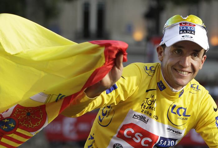 Carlos Sastre pasea con la bandera de España