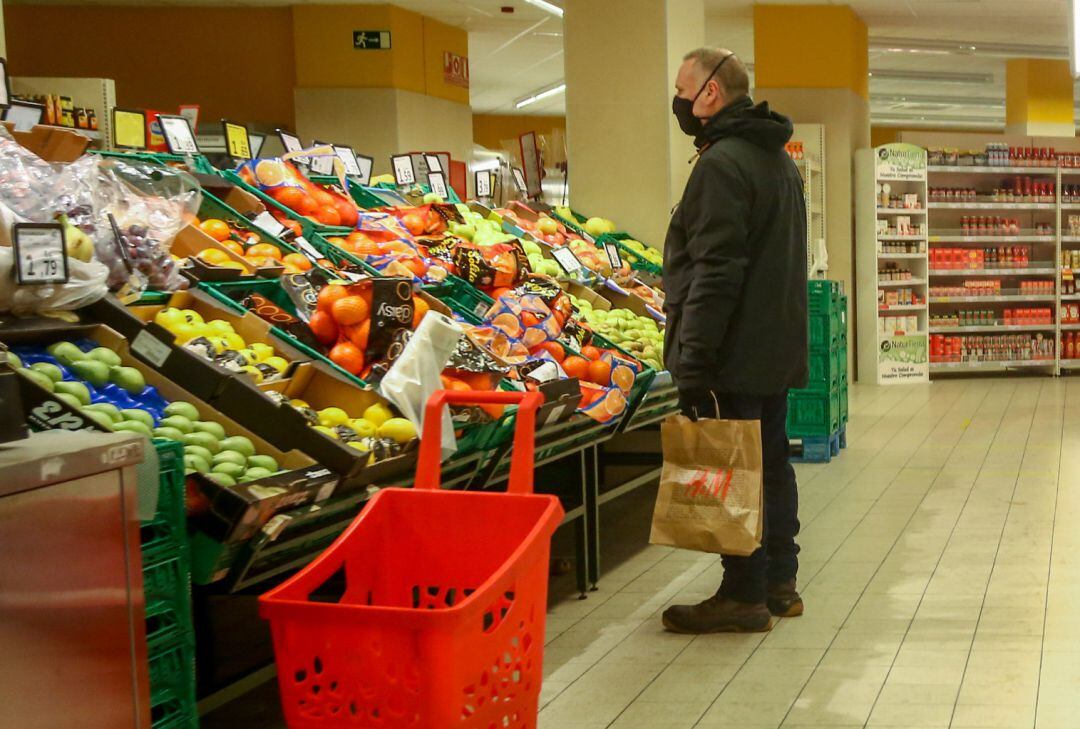 Un hombre en la sección de frutería de un supermercado