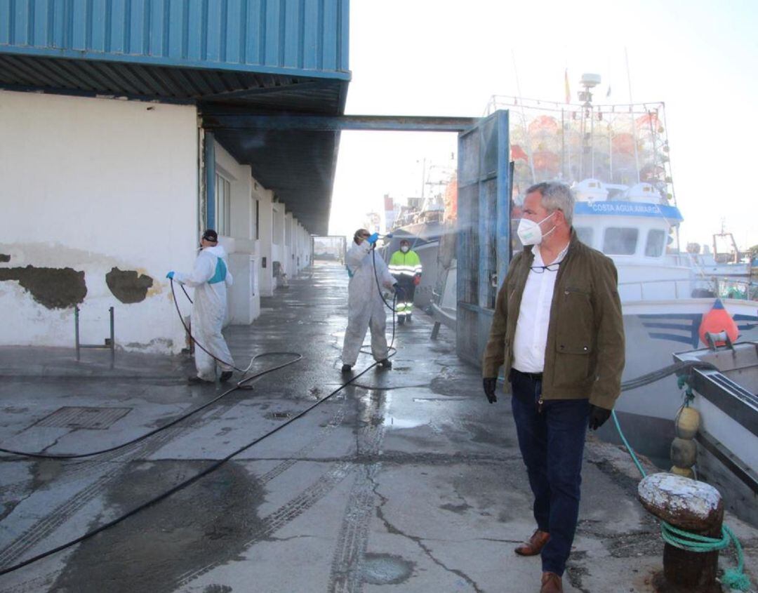 El presidente del puerto de Motril, José García Fuentes, inspecciona las tareas de desinfección de la lonja pesquera