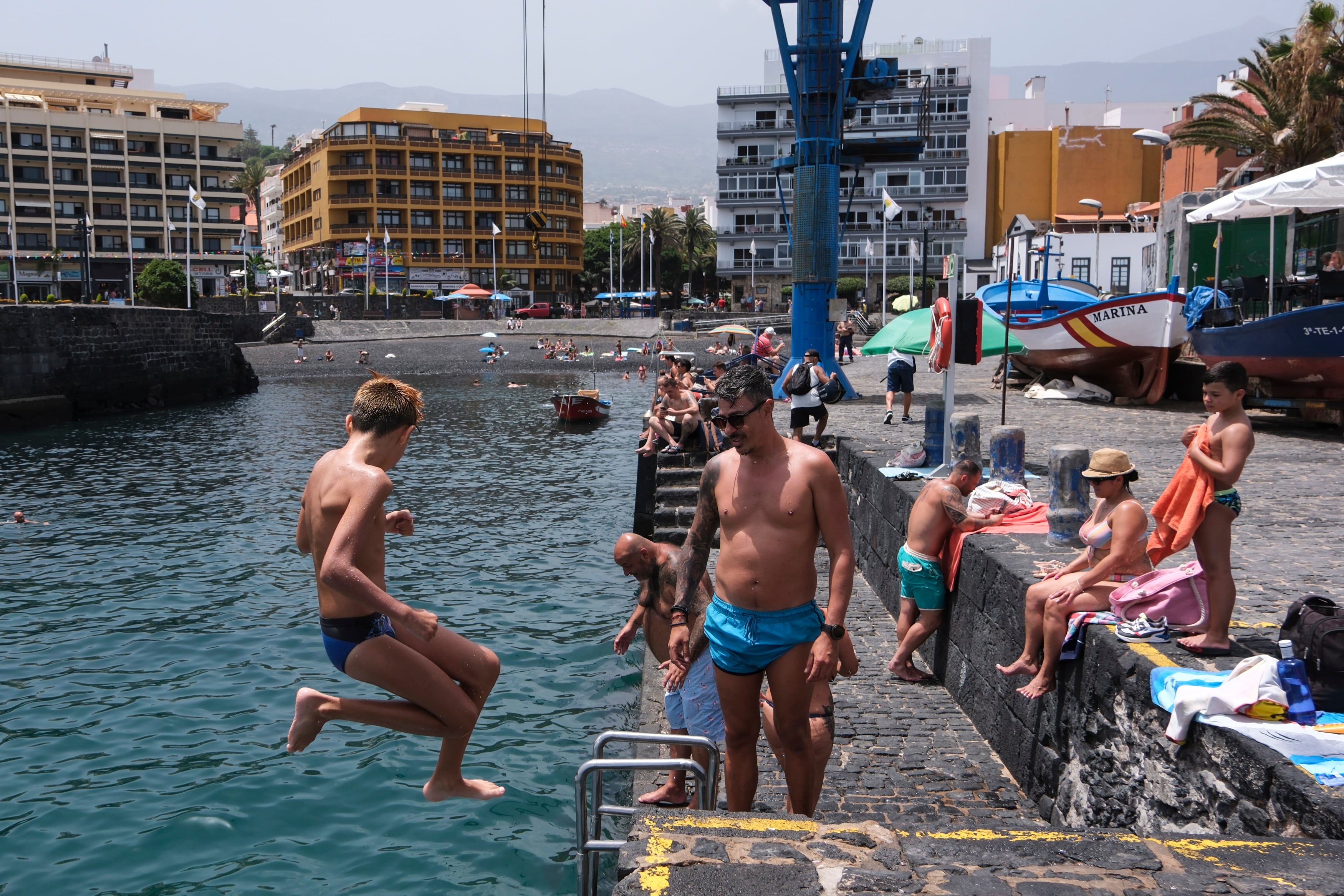 Un grupo de personas se refugia del calor bañándose en el muelle de Puerto de la Cruz (Tenerife), en una jornada de miércoles en el que toda Canarias está en aviso amarillo o naranja por altas temperaturas, que en algunas islas rozan los 40 grados Centígrados. EFE/Alberto Valdés