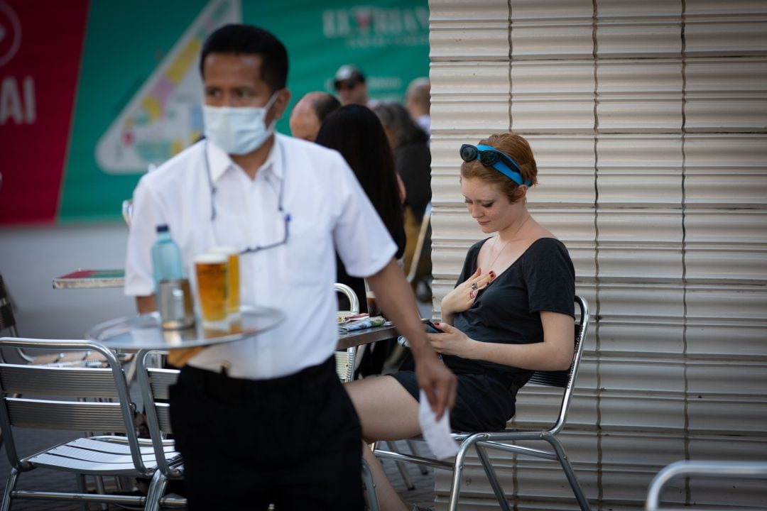 Un camarero sirve en la terraza de un bar. 