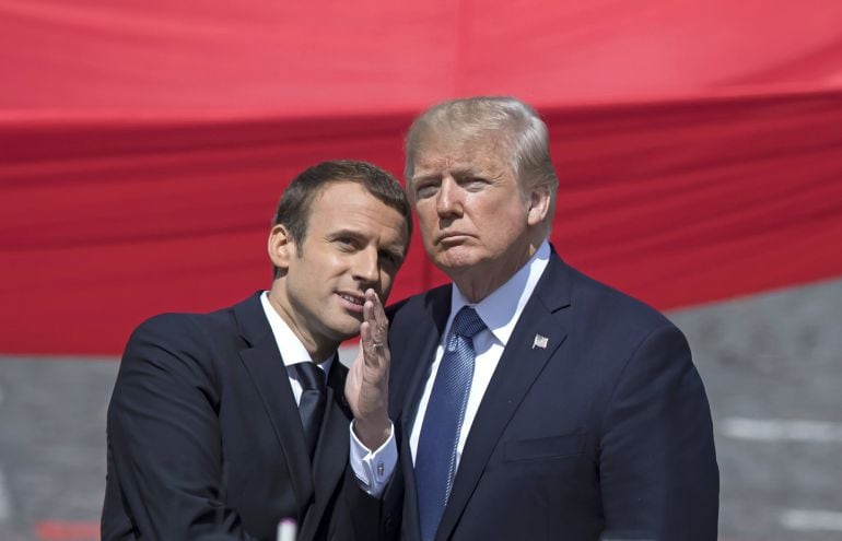 El presidente estadounidense, Donald J. Trump (dcha), conversa con su homólogo galo, Emmanuel Macron, mientras asisten al desfile militar por el Día de la Bastilla en los Campos Elíseos en París