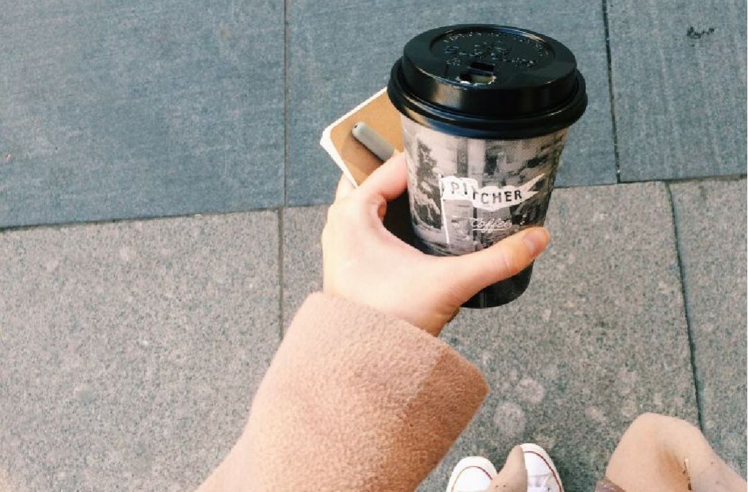 Una mujer con un café para llevar