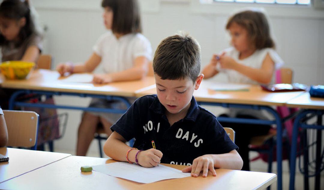 Foto de archivo de alumnos de una escuela andaluza realizando un ejercicio en sus pupitres