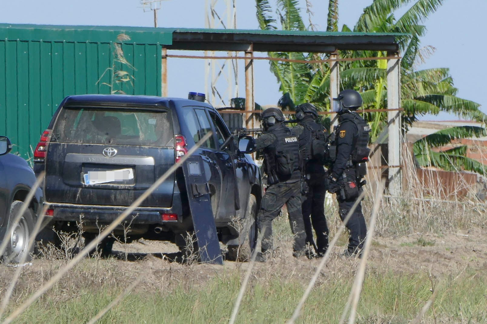 SEVILLA, 08/11/2025.- Agentes de policía desplegados frente a la nave en la que se encuentra atrincherado en Isla Mayor (Sevilla). El policía nacional herido de gravedad por un disparo se encuentra grave, pero estable, tras ser operado de urgencia en el hospital Virgen del Rocío de Sevilla. El policía participaba en una operación de vigilancia de lucha contra el narcotráfico a través del río Guadalquivir y ha resultado herido en un tiroteo durante el asalto a una 'guardería de la droga' en dicha localidad. EFE/ David Arjona