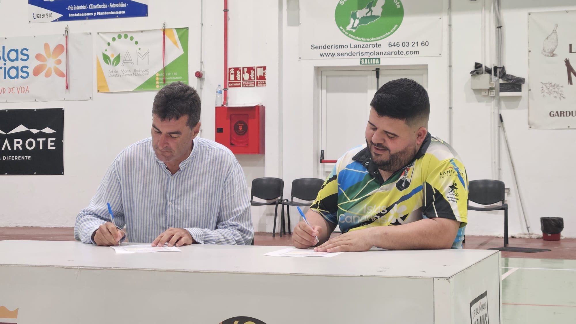 Juanmi Pérez firmando su incorporación al Zonzamas Plus Car Lanzarote, junto al presidente del club, Juan Rivera.