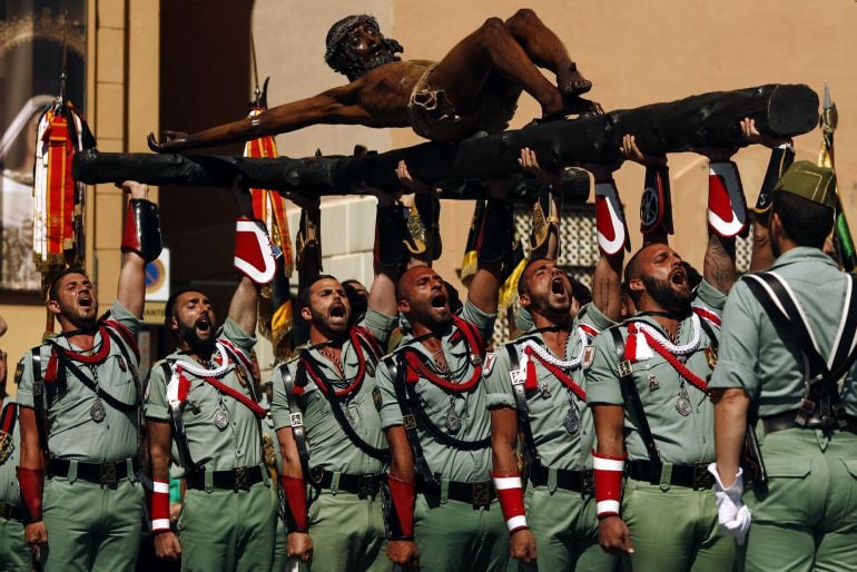 Spanish legionnaires sing an anthem as they carry a statue of the Christ of Mena outside a church during a ceremony before they take part in the &quot;Mena&quot; brotherhood procession in Malaga, southern Spain