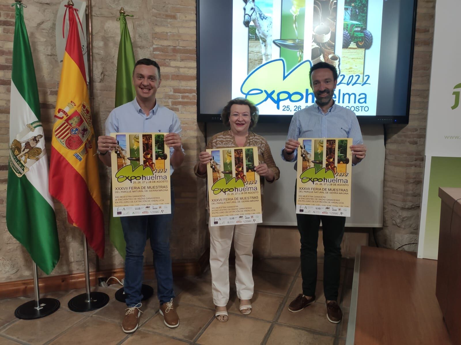 Representantes del Ayuntamiento de Huelma y la Diputación Provincial de Jaén posan con el cartel de ExpoHuelma de 2022