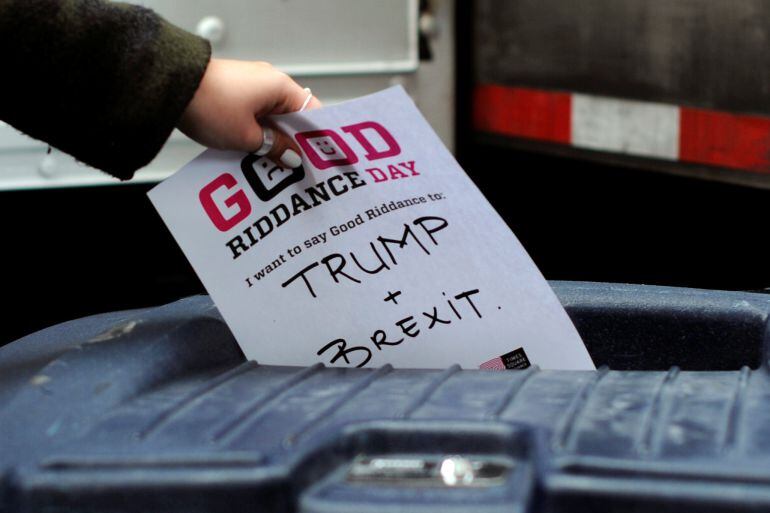 Un participante en el &quot;Good Riddance Day&quot; introduce en una papelera un papel con el mensaje &quot;Trump y Brexit&quot;. Esta jornada se organiza en Nueva York cada 28 de diciembre para dejar atrás los malos recuerdos de cada año.