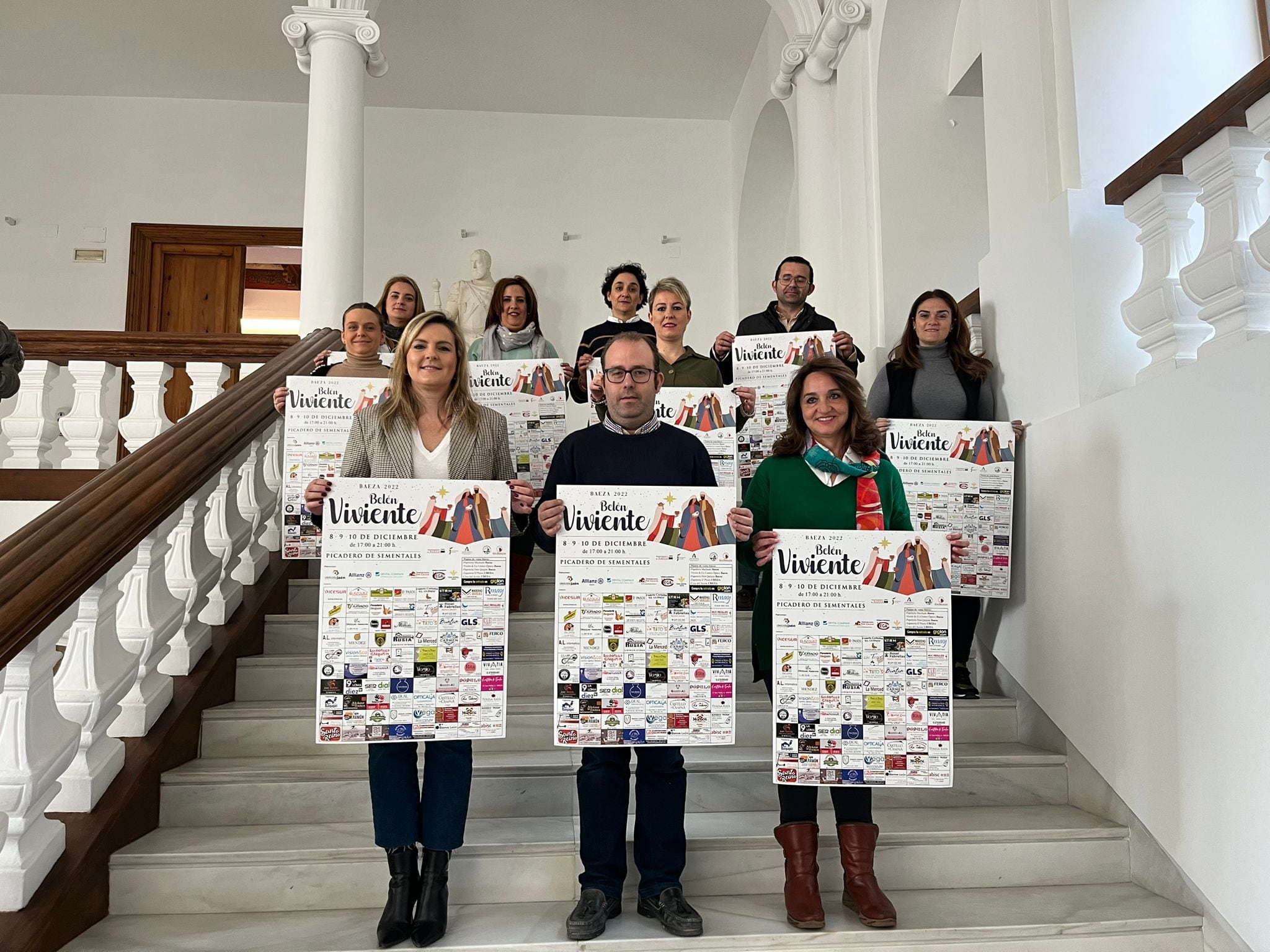 Personalidades del AMPA Los Descalzos y del Ayuntamiento de Baeza posan con los carteles del Belén Viviente de 2022