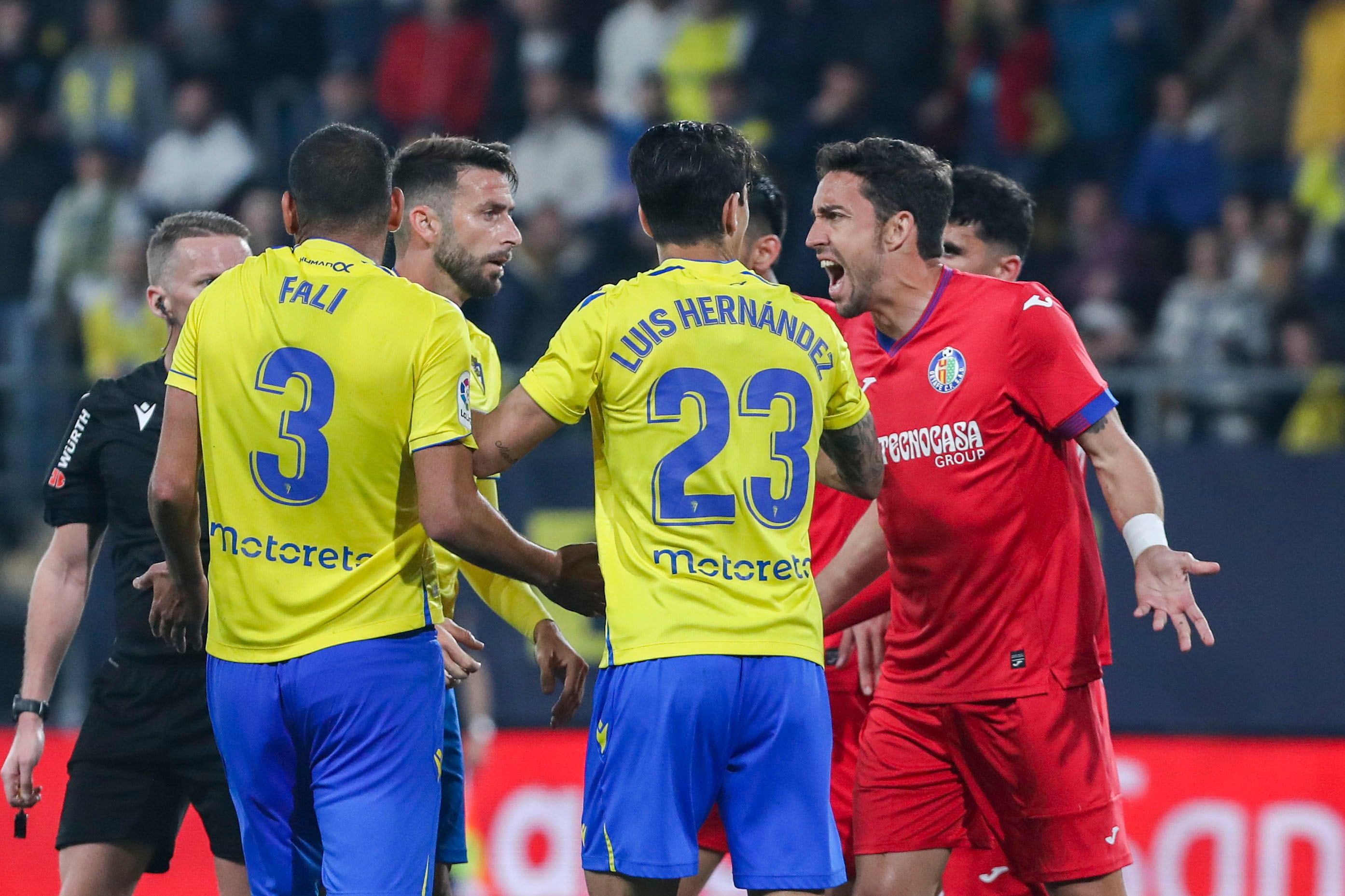 El delantero del Getafe, Jaime Mata, discute con los jugadores del Cádiz