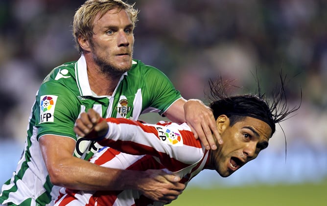 El defensa francés del Real Betis, Damien Perquis, pelea con el delantero colombiano del At. de Madrid, Radamel Falcao.