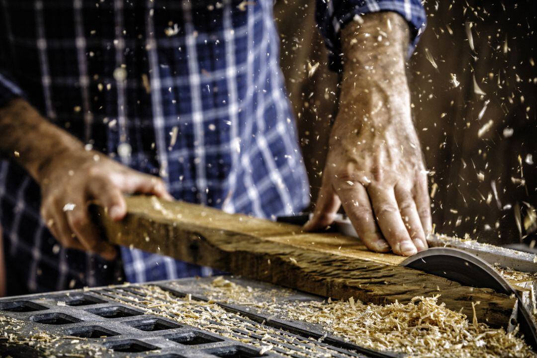 Operario trabajando con una sierra de madera