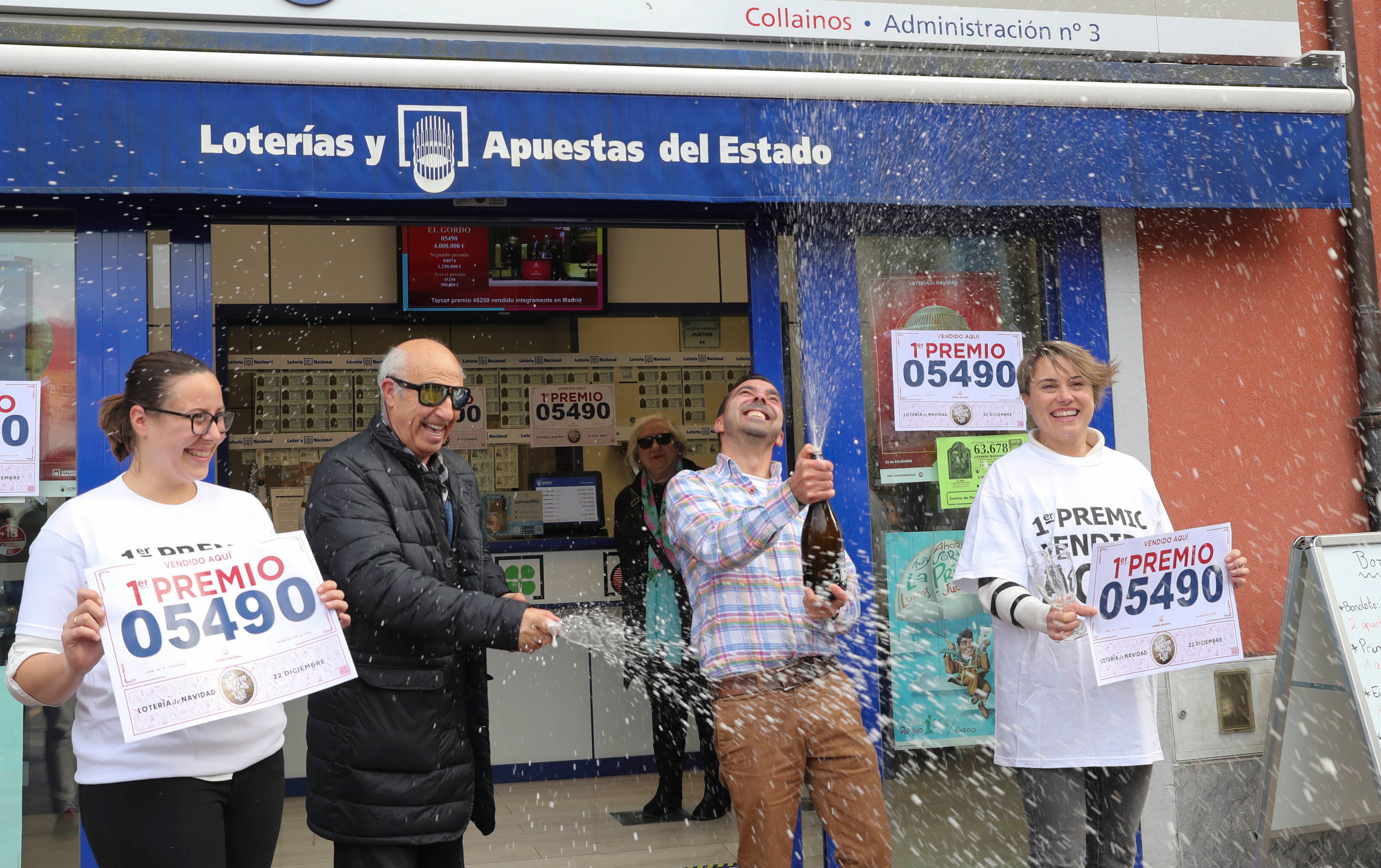 MOREDA (ASTURIAS),22/12/2022.- Responsables de la administración de lotería de la localidad asturiana de Moreda celebran este jueves el haber vendido décimos del primer premio de la Lotería de Navidad. EFE/ J.L.Cereijido
