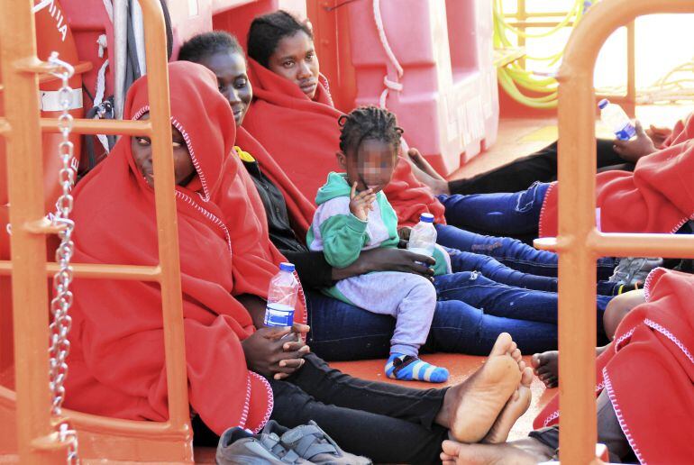 Efectivos de la Cruz Roja atienden a los treinta y tres inmigrantes de origen subsahariano, entre ellos siete mujeres y un menor de corta edad, que han llegado al puerto de Motril tras ser rescatados este sábado por efectivos de Salvamento Marítimo a 51 m