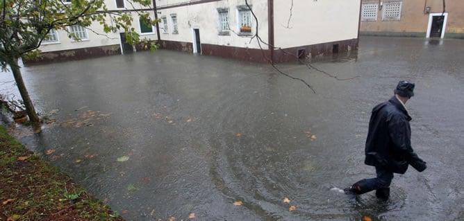 Un hombre observa el desbordamiento del río Urumea a su paso por el barrio de Martutene, en San Sebastián