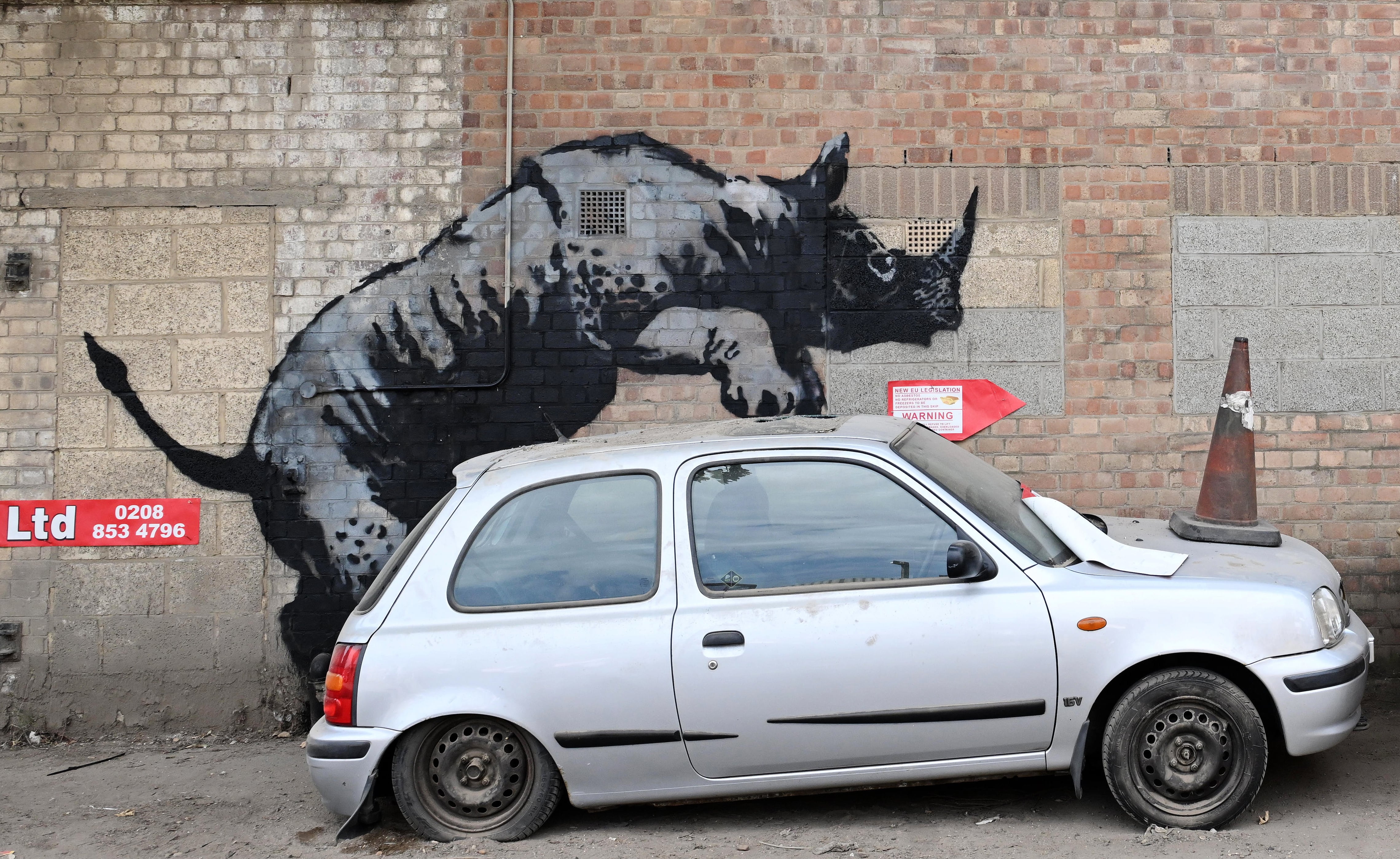 Un rinoceronte &#039;pisando&#039; un coche abandonado, en la octava obra de Banksy este verano.