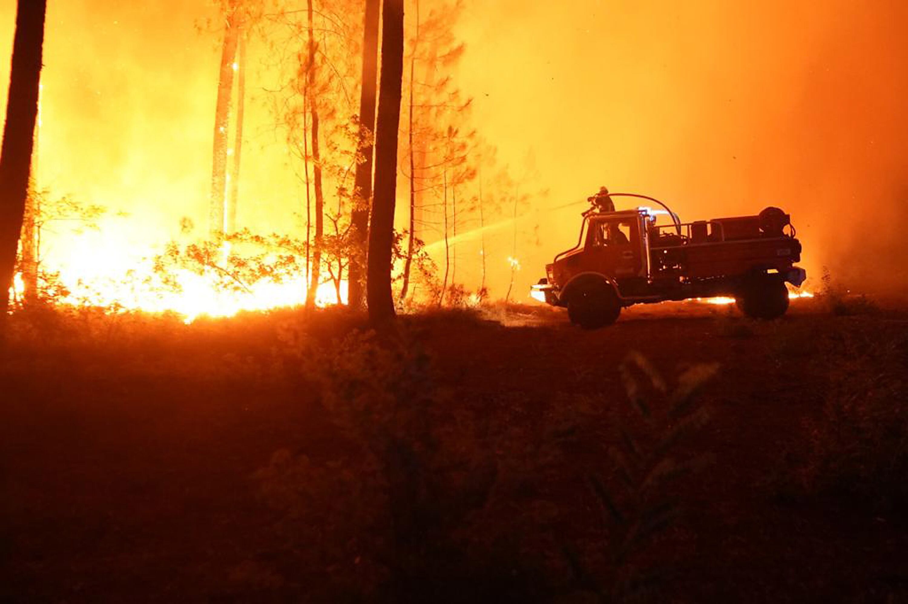 Imagen de bomberos luchando contra el incendio forestal que afecta a Hostens, en el departamento de Gironde, este jueves. / HANDOUT/SDIS 33 HANDOUT (EFE)