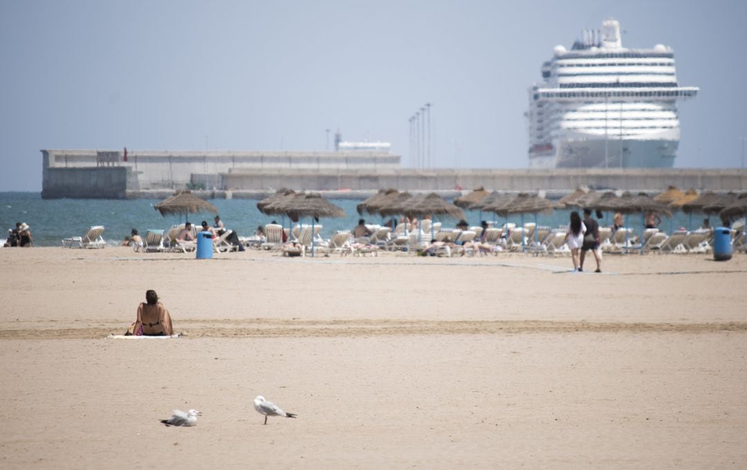 Una mujer descansa en la arena de la playa de la Malvarrosa de Valencia en un soleado día