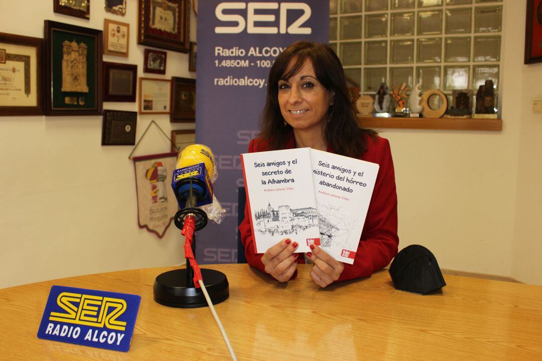 Andrea Latorre muestra los dos libros que tiene publicados de la colección 'Seis amigos' en el estudio central de Radio Alcoy