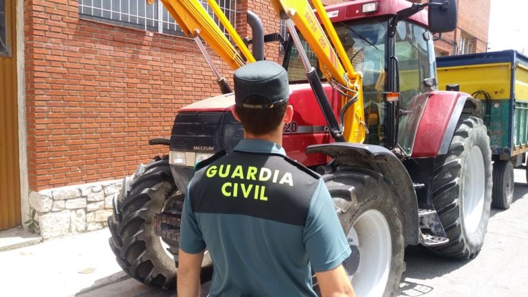 Un agente de la Guardia Civil ante uno de los vehículos afectados