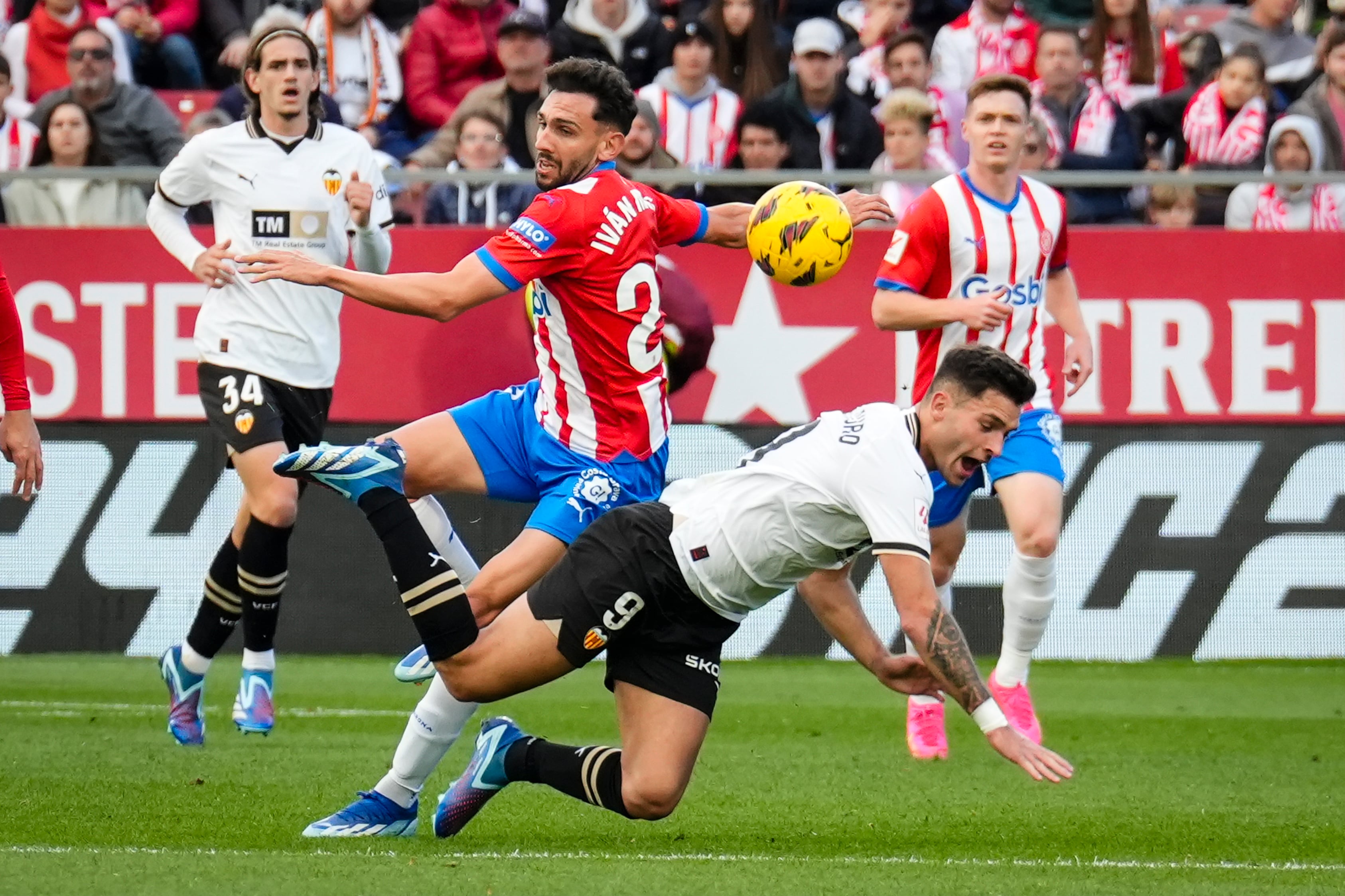 Girona, 02/12/2023. El centrocampista del Girona Iván Martín (ci), disputa una posesión ante Hugo Duro, delantero del Valencia durante el partido correspondiente a la jornada 15 de LaLiga que ambos clubes disputan este sábado en el estadio municipal de Montilivi. EFE/ David Borrat
