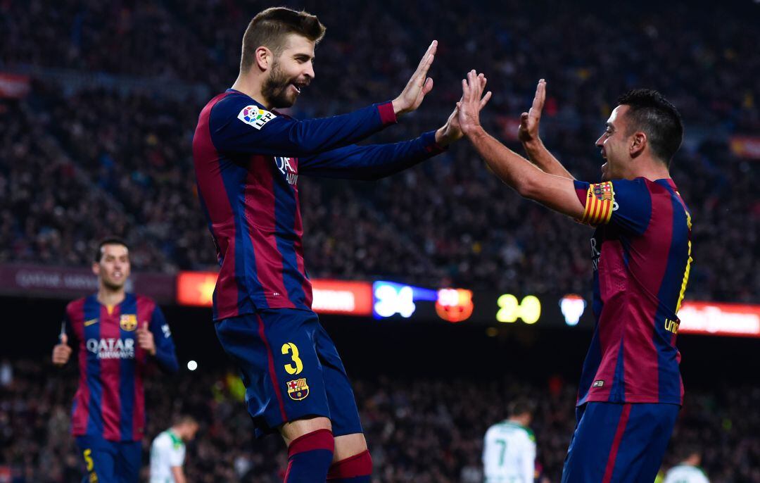 Piqué y Xavi celebran un gol en 2014