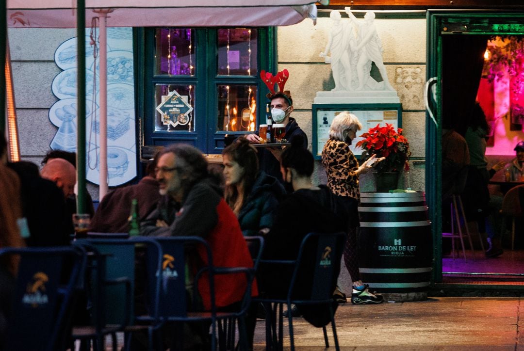 A pesar de las nuevas restricciones, como el uso de la mascarilla en exteriores, varias personas quedan en terrazas y bares para reunirse y celebrar la llegada de la Navidad. 