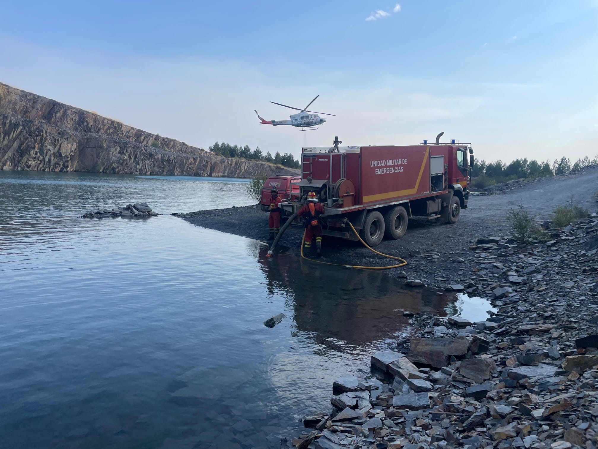 Un helicòptero carga agua en presencia de la UME