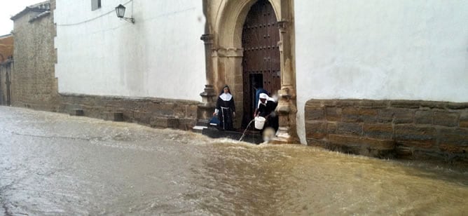 Varias monjas achican agua a las puertas de su convento, tras las fuertes lluvias caidas en la localidad jienense de Baeza