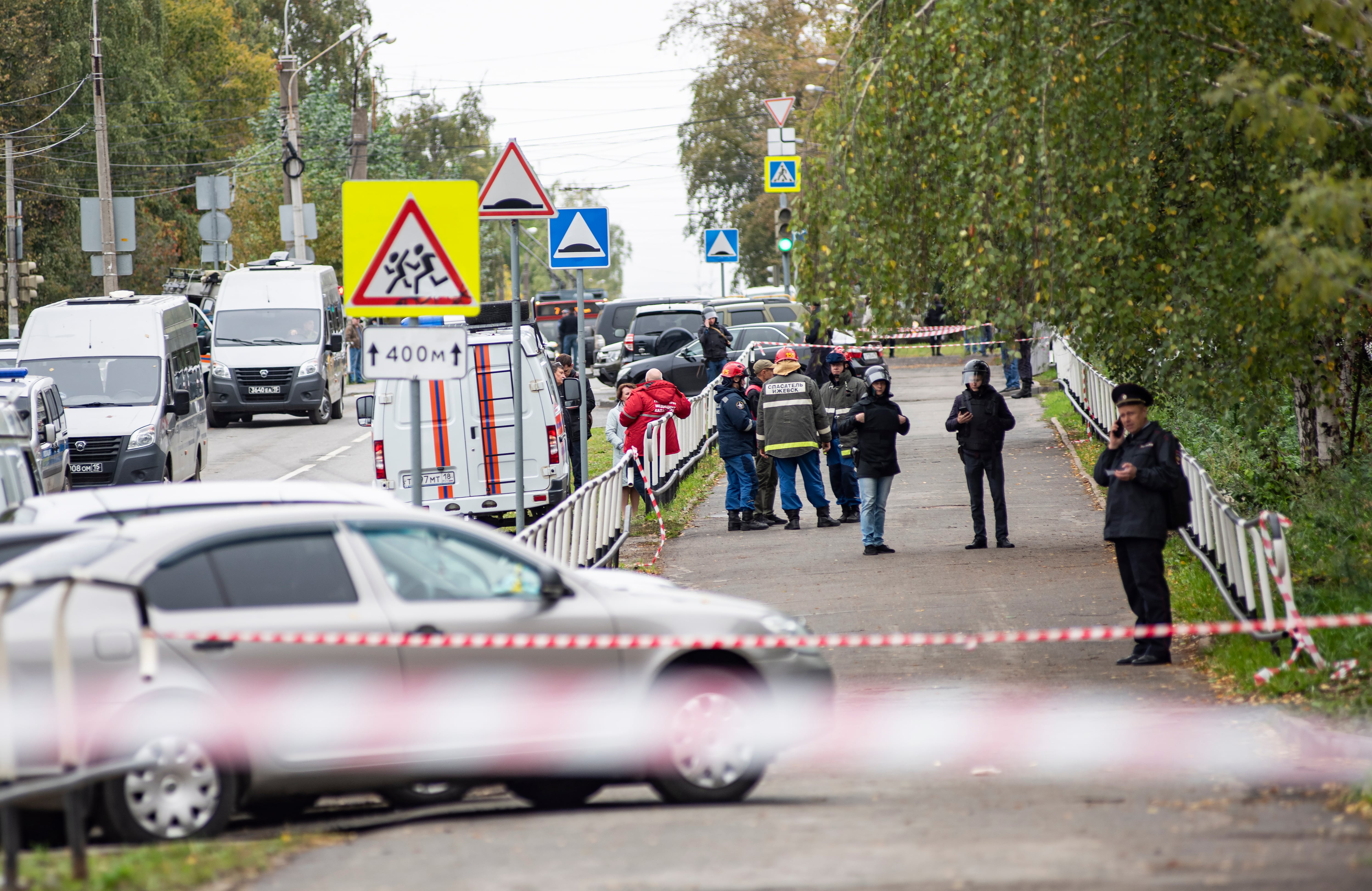 Policías rusos y miembros de los servicios de emergencias permanecen en las inmediaciones de la escuela de Izhevsk en la que al menos trece personas murieron, siete de ellas menores de edad, en un tiroteo