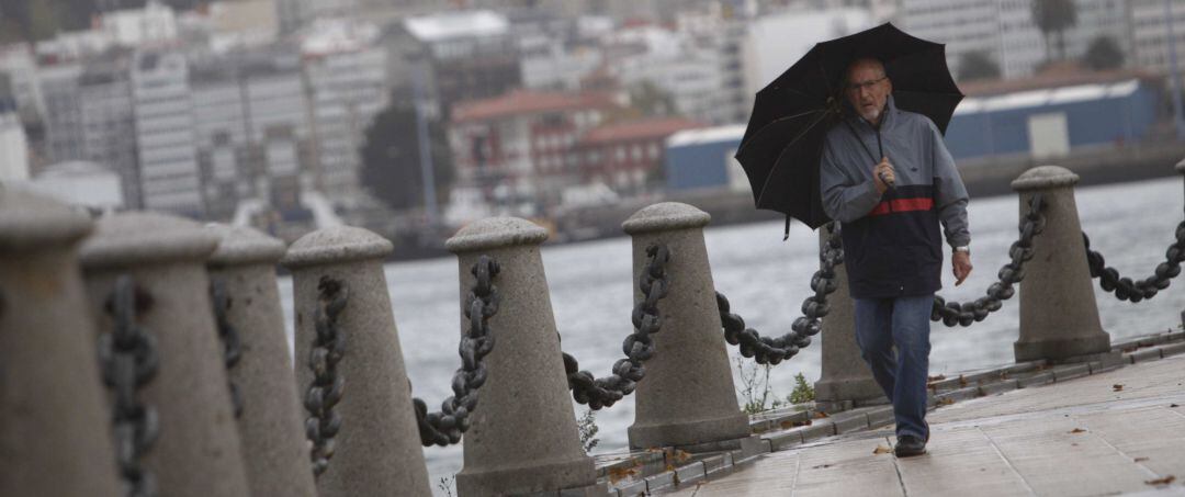 Un hombre camina en medio de la lluvia