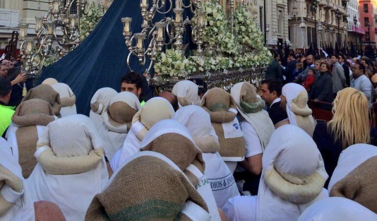 Relevo de costaleros junto al Banco de España en el palio de la Hermandad de La Sed