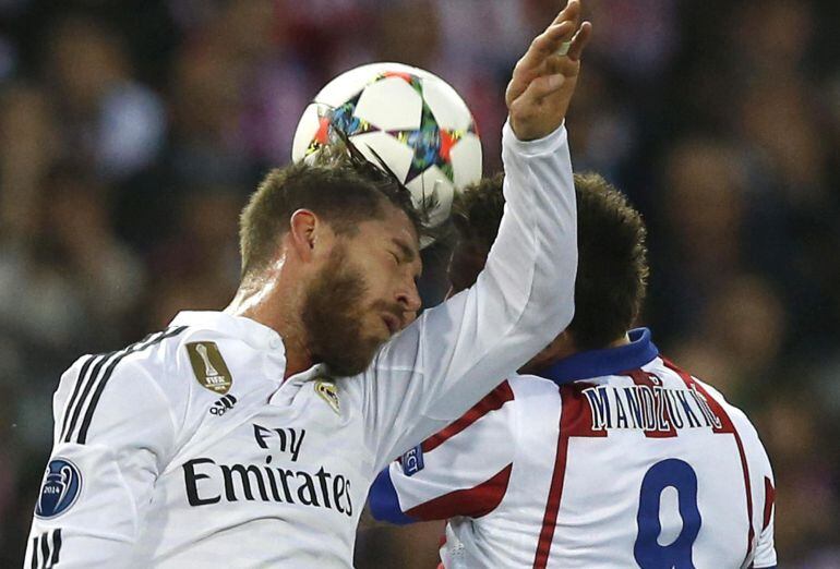 GRA463. MADRID, 14/04/2015.- El delantero croata del Atlético de Madrid Mario Mandzukic (d) lucha el balón con Sergio Ramos, del Real Madrid, durante el partido de ida de cuartos de final de Liga de Campeones que se disputa esta noche en el estadio Vicent