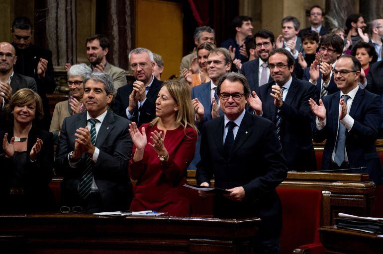 BARCELONA, SPAIN - NOVEMBER 09:  Acting President of Catalonia Artur Mas (R) looks on as Junts Pel Si (All together for Yes) members of the Catalan parliament celebrate at the end of the parliamentary session on November 9, 2015 in Barcelona, Spain. The C