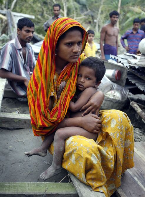 Una mujer con su hijo en lo que queda de su casa en Bakerganj