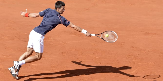 El tenista serbio Novak Djokovic devuelve la pelota al suizo Roger Federer durante la semifinal de Roland Garros en París, Francia hoy 8 de junio de 2012