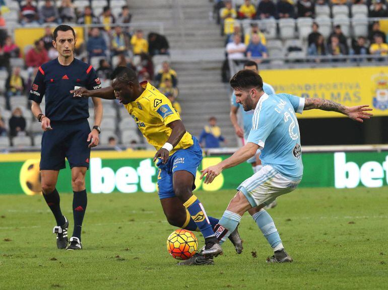 El defensa del Celta de Vigo Carles Planas (d) y el centrocampista de la U.D. Las Palmas Wakaso Mubarak pelean un balón durante el partido correspondiente a la vigésima segunda jornada de liga en Primera División que ambos equipos disputaron en el estadio