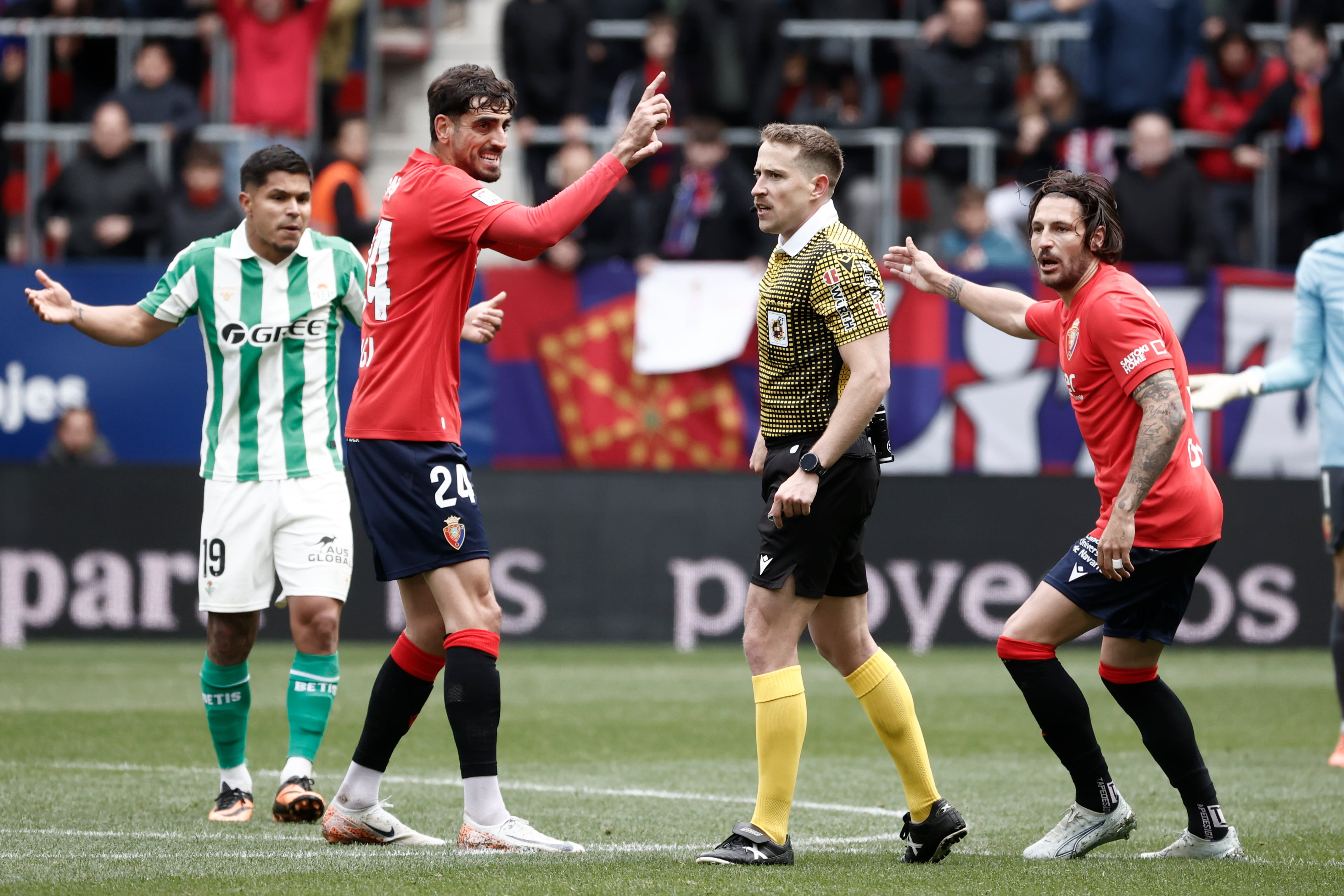 Catena y Juan Cruz junto al Cucho y el árbitro Sesma Espinosa, durante el partido entre el Real Betis y Osasuna, en el estadio de El Sadar