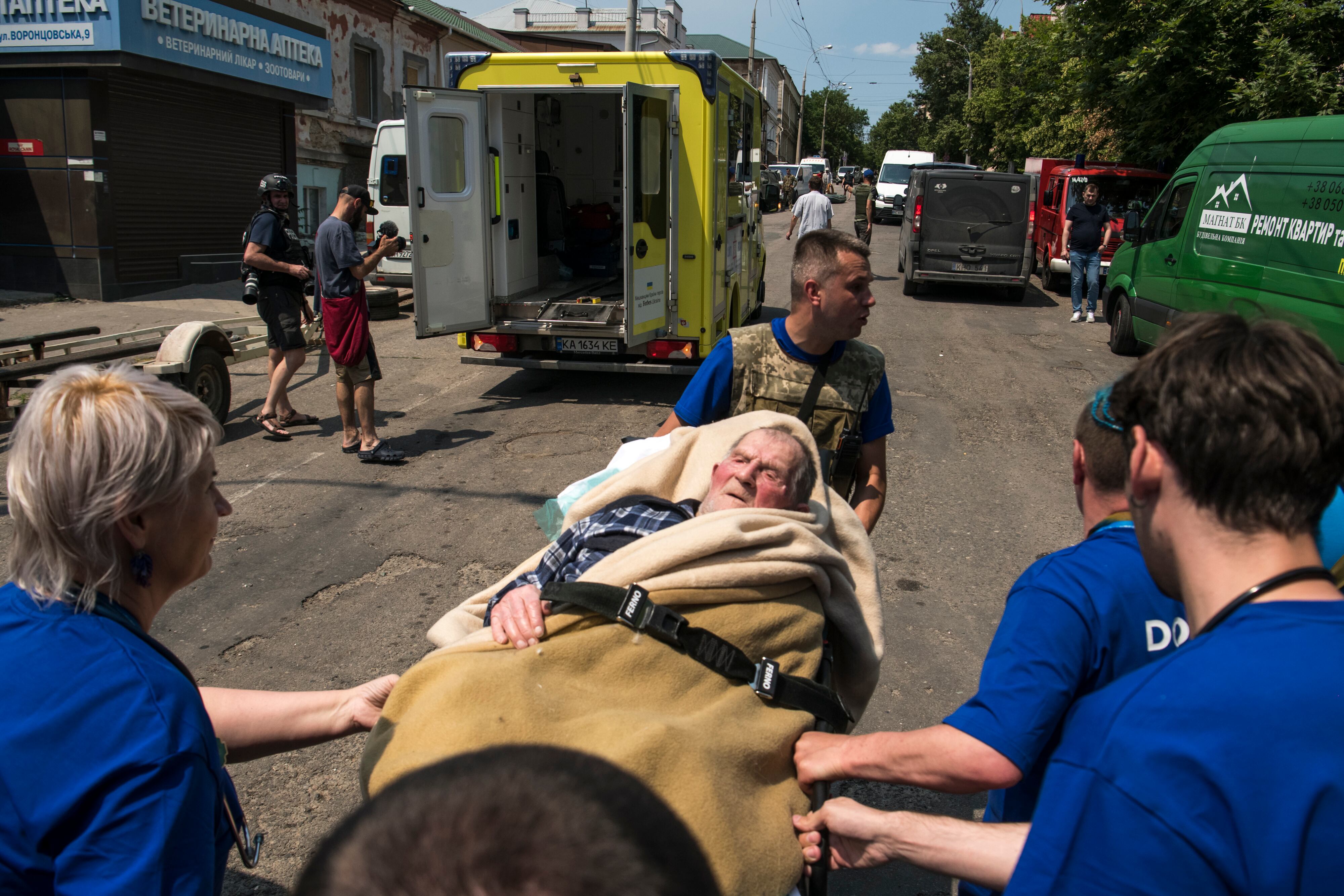 Voluntarios de Cruz Roja  y residentes ayudan en las tareas de evacuación de afectados por el derrumbe de la presa de Kajovka