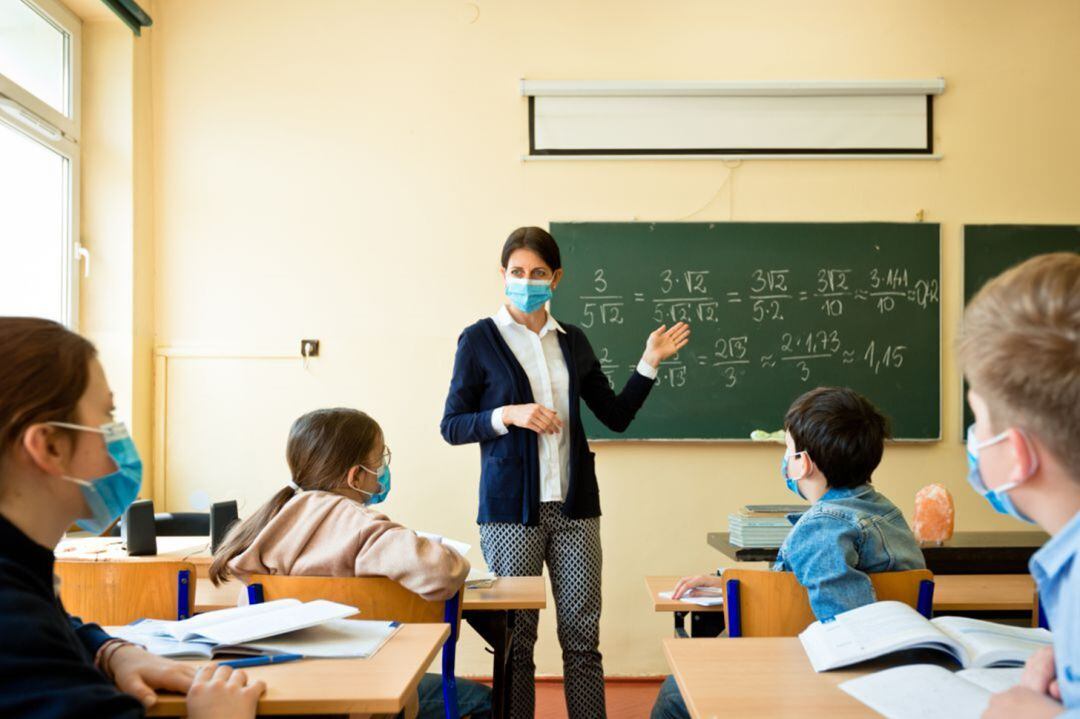 Niños asisten a una clase presencial dotados con mascarillas.