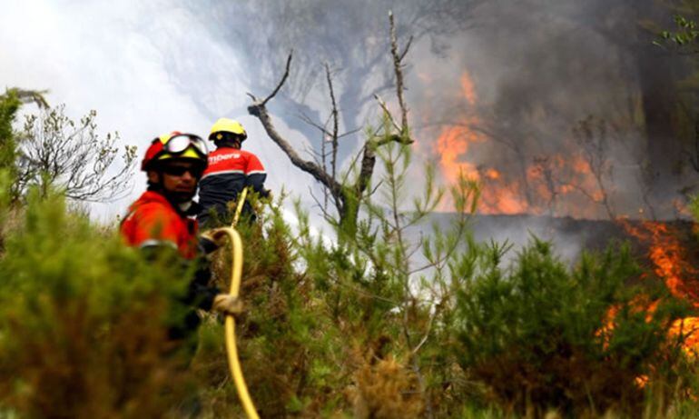 Dos bomberos en el incendio de La Torre de les Maçanes