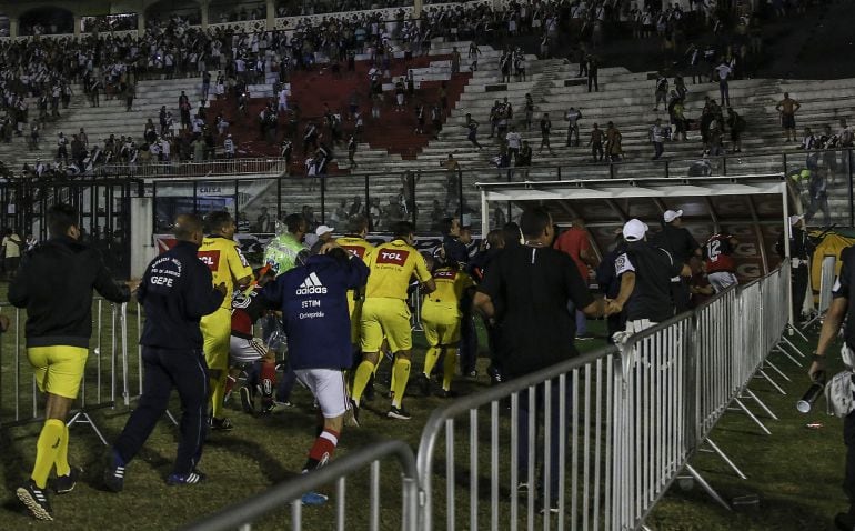 Los jugadores de Flamengo y los jueces del partido buscan refugio en los vestuarios 